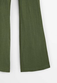 Pantalon en lin vert olive à jambes larges, présenté de la mi-cuisse à l'ourlet sur fond blanc.