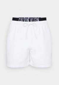Bijele kratke hlače s elastičnim pojasom i vezicom, s crnim Calvin Klein logotipom na pojasu. Glatka tekstura, ležeran dizajn.