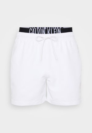 Valged lühikesed püksid, millel on elastne vöökoht ja pael, ning vöökoha peal must Calvin Kleini logo. Sile tekstuur, lõõgastav disain.