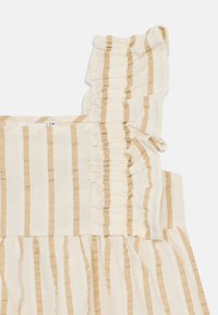 Robe à bretelles avec des rayures verticales beiges et blanches, ornée de volants sur les bretelles et d'une jupe froncée. Texture de tissu douce.