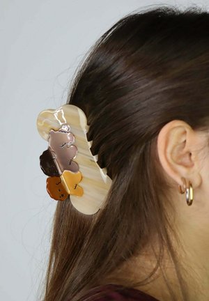 Spinka do włosów wykonana z warstwowego akrylu w beżowych i brązowych odcieniach, z ząbkowanym wzorem, błyszczącą teksturą i kwiatowymi akcentami.