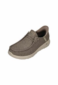 Light brown woven slip-on shoes with a cushioned sole and subtle branding, featuring a rounded toe and lacing detail on the front.