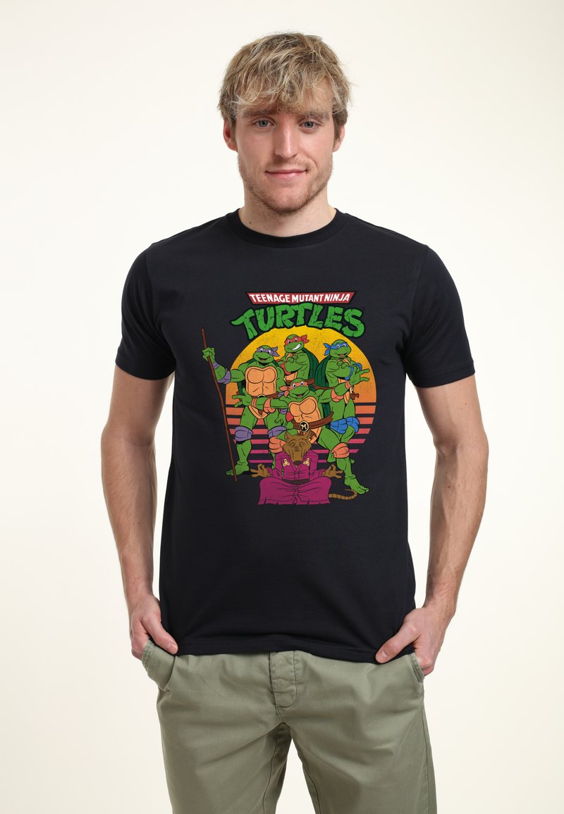 T-shirt in cotone nero con personaggi cartoon colorati delle Tartarughe Ninja, dotata di una stampa grafica vivace e un taglio morbido.