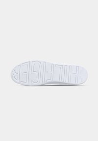Fehér sneaker talp, textúrált gumival, a "HILFIGER" felirattal domborúan, tiszta, geometrikus dizájnnal.