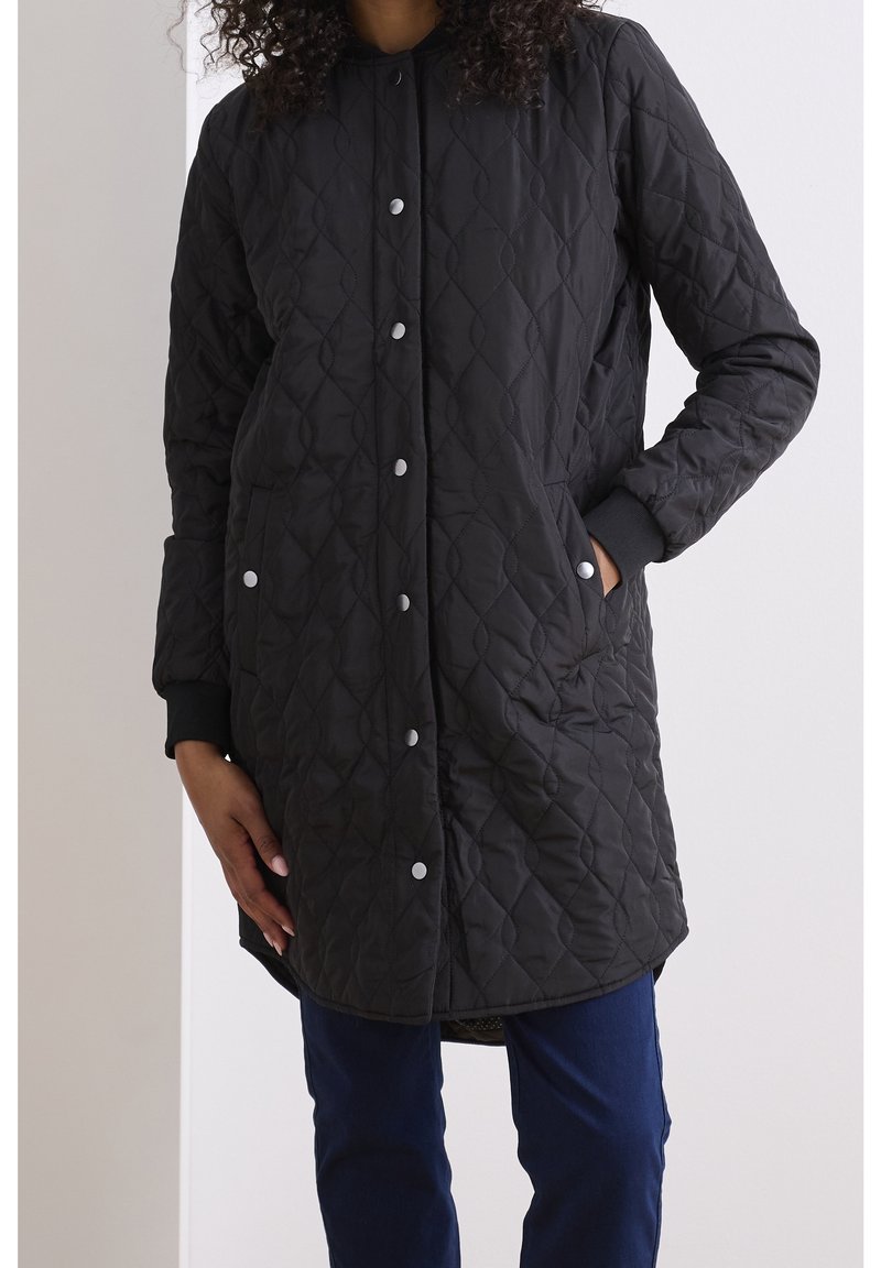 Schwarze, gesteppten lange Jacke mit rundem Ausschnitt, Druckknöpfen und Seitentaschen. Sie hat ein strukturiertes Muster und gerippte Bündchen.