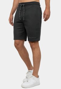 Zwarte katoenen shorts met een elastische tailleband en koord. Voorzien van zijzakken en een geborduurd merkvak op de voorkant.