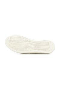 Suola di sneaker bianca con una superficie in gomma testurizzata, caratterizzata da un motivo a spina di pesce e un logo circolare al centro.