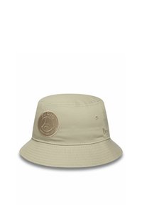 Cappello a secchiello beige con un logo ricamato rotondo che presenta "PARIS SAINT-GERMAIN". Tessuto morbido e ampia visiera inclinata verso il basso.