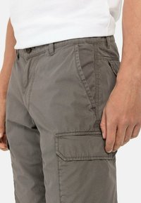 Grå cargobukser i et struktureret stof, med sidelommer og knaplukning. Designet inkluderer stitched detaljer for holdbarhed.
