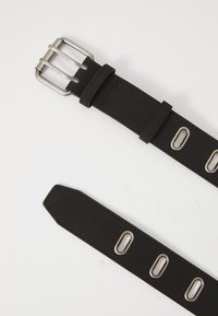 Zwarte leren riem met een zilverkleurige metalen gesp en oogjes, met een gladde textuur en een spitse punt. Eenvoudig ontwerp met een verstelbare pasvorm.