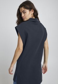 Marineblå overdreven ærmeløs sweatshirt med høj krave og sidesslids, lavet af blødt stof, med en afslappet pasform og glat tekstur.