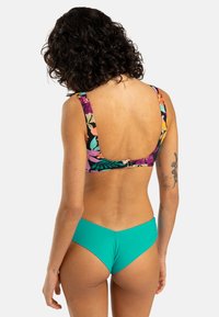 Bikini with a floral-patterned black top and turquoise bottoms. The top features wide straps and a low back design.