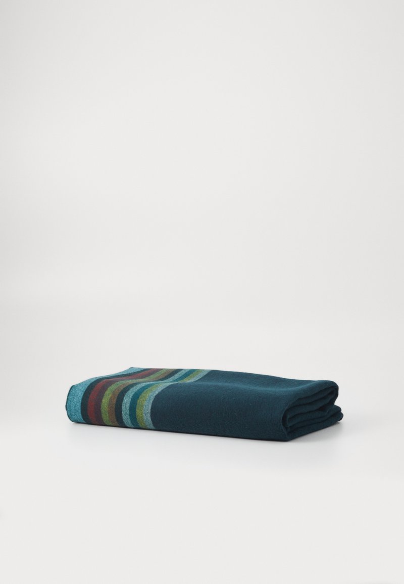 Folded wool blanket in dark teal, featuring horizontal stripes in green, red, and blue. Soft texture with a clean, smooth finish.