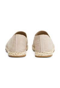 Beige espadrilles met een geweven jute zool, bovenwerk van textuurstof, rond neuzenontwerp en eenvoudige stikdetails aan de achterkant.