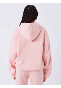 Lichtroze oversized hoodie met capuchon en trekkoord. Voorzien van geribde manchetten en een zachte, gestructureerde stof voor comfort.