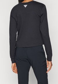 Black long-sleeve cropped sweatshirt with a round neckline, smooth texture, and a small triangle logo at the upper back.
