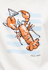 Φωτεινή πορτοκαλί γραφική απεικόνιση αστακού με μαύρο περίγραμμα και παγιέτες σε λευκό φόντο με ανοιχτό μπλε οριζόντιες ρίγες, με ετικέτα "Marc Cain Sports".