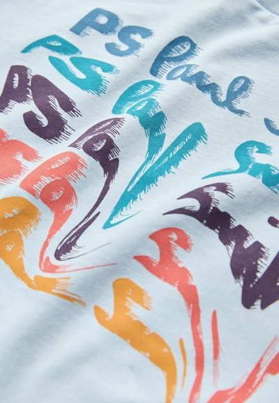 Svetlo modra tkanina z večbarvnimi besedili v abstraktnih vzorcih, ki spominjajo na poteze čopiča. Barve vključujejo turkizno, vijolično, oranžno in rdečo.