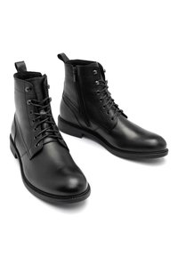 Botas de cuero negras hasta el tobillo con punta redonda, cordones en la parte delantera y cremallera lateral. Presentan un acabado texturizado y una suela resistente.