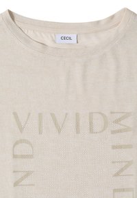 T-shirt beige col rond avec étiquette « CECIL » et texte en relief épelant « VIVID MIND » entourant un motif circulaire ponctué sur le devant.