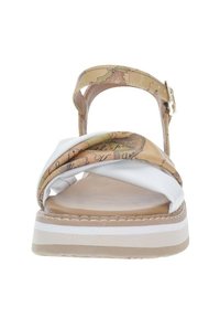Sandali marroni e bianchi con un design a strap twisted, decorati con una stampa mappale e suola piatta spessa con strisce bianche e texture liscia.
