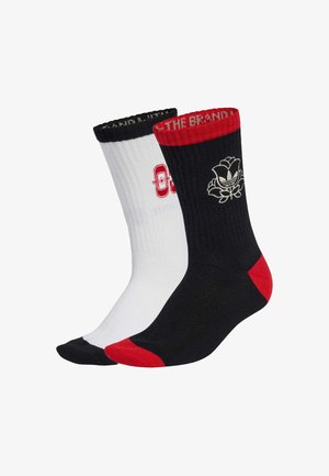 Schwarz-weiße Sportsocken mit roten Akzenten. Die schwarze Socke zeigt ein Rosen-Logo, die weiße Socke hat eine rote Grafik. Rippstricktextur, lässiges Design.