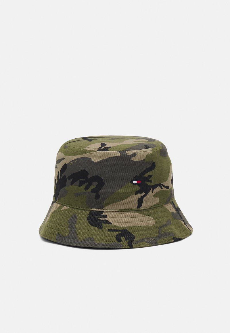 Bob à motif camouflage dans des tons de vert, marron et noir avec un petit logo rectangulaire rouge, blanc et bleu sur le côté.