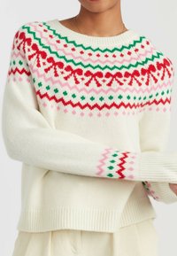 Chunky cream sweater with colorful knitted pattern in red, green, and pink. Featuring a crew neckline and ribbed cuffs and hem.