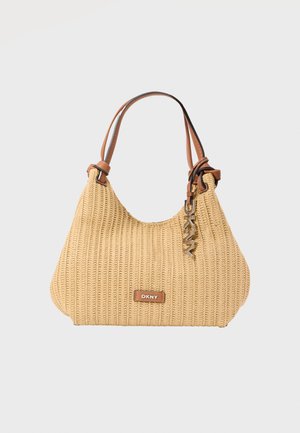 Bézs szövött válltáska barna bőrpántokkal és DKNY logóval díszített medállal, amely az egyik pánton lóg.
