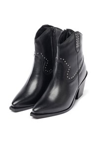 Botas de cuero negras hasta el tobillo con punta afilada, cremallera lateral y acentos de tachuelas. Cuentan con un tacón cuadrado y una textura suave.
