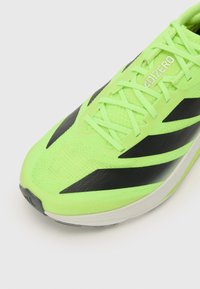 Neon groene hardloopschoen met een gestructureerde mesh bovenkant, zwarte accenten en een gestroomlijnd ontwerp. Voorzien van heldere veters en een comfortabele zool.
