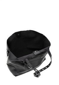 Borsa tote in pelle nera con un interno morbido; presenta manici con borchie e una chiusura con zip. Il design aperto offre ampio spazio di archiviazione.