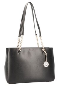 Sac à main en cuir noir avec anses en chaîne et cuir, forme structurée, ferrures argentées, logo DKNY et un pendentif rond attaché.