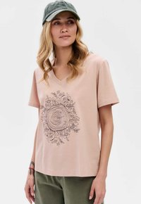 Lichtroze V-hals t-shirt van katoen, met een zwart lijntekening van een boomstam omringd door bloemelementen.