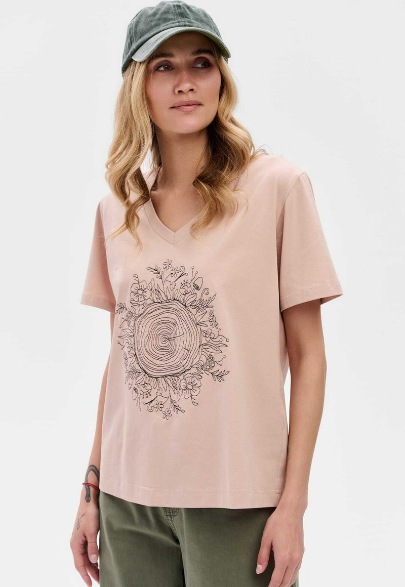 Lichtroze V-hals t-shirt van katoen, met een zwart lijntekening van een boomstam omringd door bloemelementen.