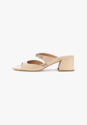 Sandale mule beige à bout ouvert avec talon bloc, large bride avant et bride arrière ajustable avec boucle sur fond blanc.
