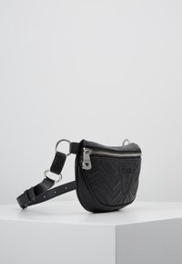 Borsa a tracolla in similpelle nera con motivo a chevron, ferrature argentate e scomparto con zip. Tracolla regolabile e dettaglio di marchio distintivo.