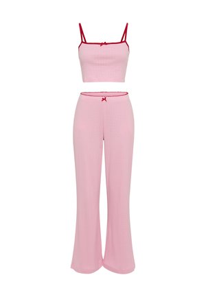 Pink ribbed two-piece set featuring a cropped top with thin straps and matching flared pants. Red accents at the straps and waistband.