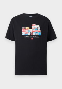 Μαύρο βαμβακερό T-shirt με γραφικό που απεικονίζει στοιβαγμένα πολύχρωμα κουτιά παπουτσιών και το κείμενο «Το σημαντικό είναι το περιεχόμενο» από κάτω. Κοντά μανίκια.