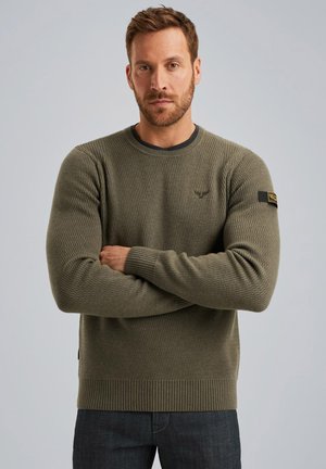 Olive green knitted sweater with ribbed cuffs and hem, featuring a textured pattern and a small logo detail on the chest.