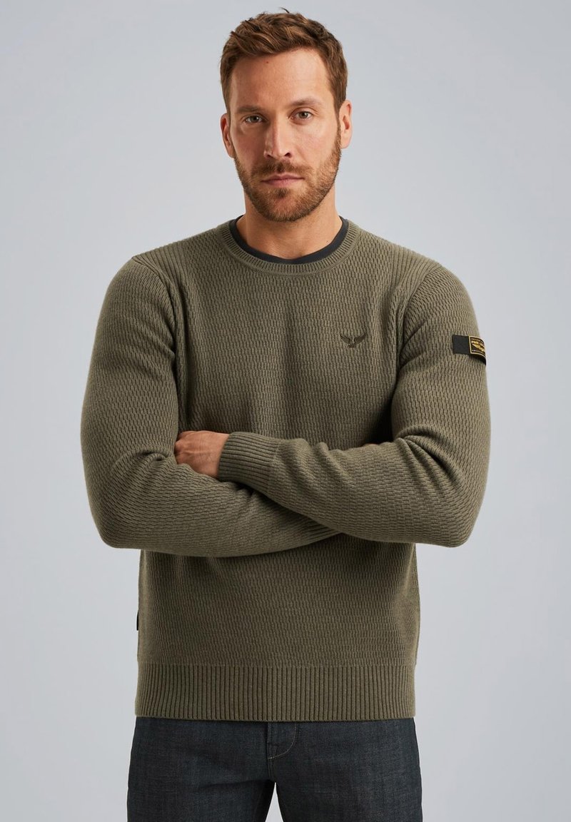 Olivgrüner gestrickter Pullover mit gerippten Bündchen und Saum, der ein strukturiertes Muster und ein kleines Logodesign auf der Brust aufweist.