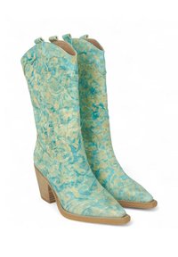 Un par de botas de vaquero turquesas hechas de cuero texturizado, con un patrón floral, punteras afiladas y tacones de madera apilados.