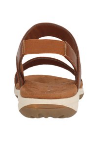 Sandales en cuir marron avec trois sangles en tissu réglables, une semelle intérieure en cuir tan rembourrée et une semelle extérieure en caoutchouc texturé.