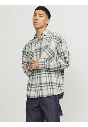 Long-sleeve, plaid shirt in cream, navy, and gray, featuring two chest pockets and button front closure. Soft, woven fabric with a relaxed fit.