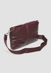 Burgunderfarbene Leder-Umhängetasche mit strukturiertem Finish, Reißverschluss und verstellbarem Stoffgurt. Sie hat eine rechteckige Form und gestickte Akzente.