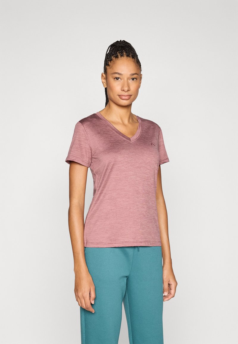 Μπλουζάκι V με κοντά μανίκια σε αποχρώσεις μουβ, κατασκευασμένο από ελαφρύ ύφασμα, συνδυασμένο με μπλε-πράσινη φόρμα. Απλός σχεδιασμός με διακριτική εμπορική σήμανση.