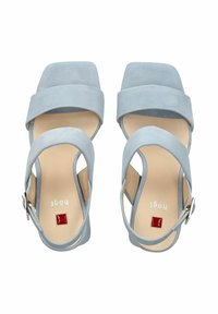 Sandalias de tacón de ante azul claro con punta cuadrada, dos correas anchas en la parte superior, una correa en el tobillo con hebilla y un acento rojo.