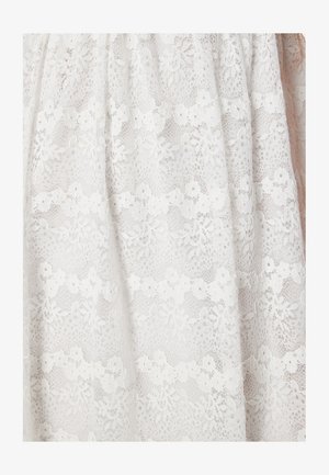 Tessuto in pizzo bianco con motivi floreali e dettagli intricati, che presenta una texture semitrasparente con un aspetto delicato e a strati.