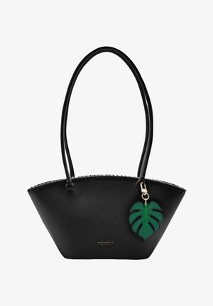 Sac à main trapèze noir avec longues anses, breloque décorative feuille de monstera verte et logo "Seidenfelt" en lettres dorées.