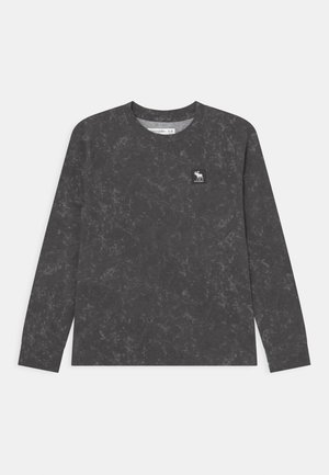 Ciemnoszara koszula z długim rękawem z subtelnym marmurkowym wzorem oraz małą naszywką z logo przedstawiającą łosia na górnej lewej stronie klatki piersiowej.